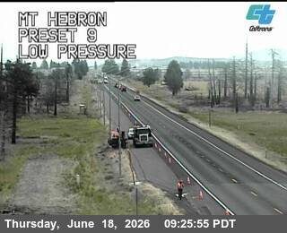 Road work with personnel and cones on the shoulder of the highway.
