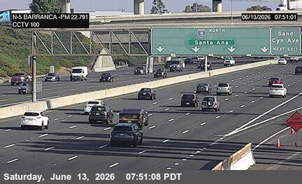Emergency vehicle and cones on the right shoulder, indicating a lane closure.