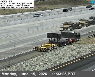 Construction workers and equipment on the side of the highway.