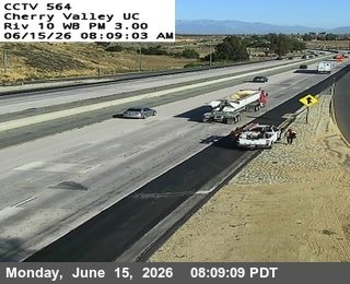 Roadside assistance vehicle and personnel attending to a white vehicle on the shoulder.