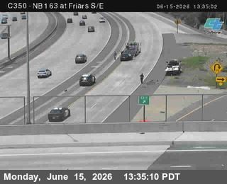 Police car and person on highway shoulder near exit ramp.