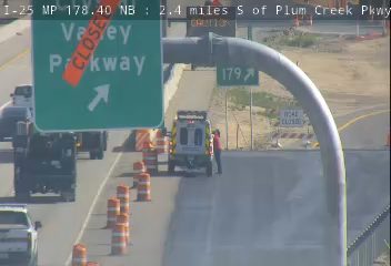 Road work crew with vehicle and cones on the highway shoulder.