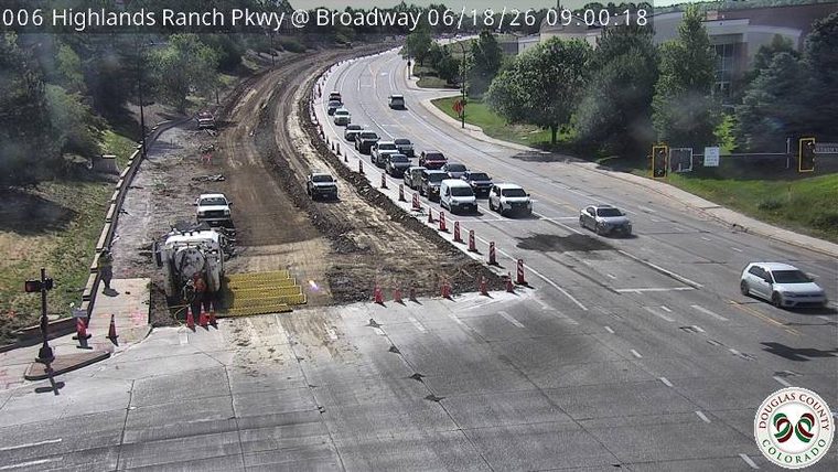 Construction zone with workers and equipment on the roadway.
