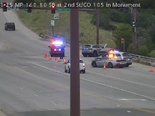 Police and emergency vehicles on scene with lights flashing and blocking traffic.
