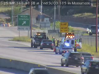 Emergency responders and vehicles are present at a roadside incident.
