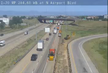 Construction vehicles and personnel on the shoulder of the highway.