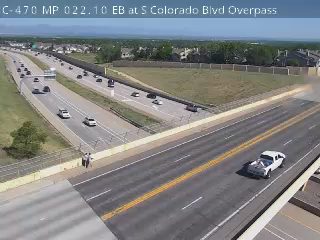 Police officer standing on the side of the road near a white vehicle.