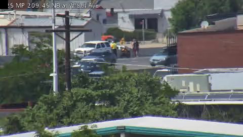 Emergency responders and vehicles are present at a roadside incident.