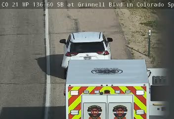 Ambulance on scene with a white SUV on the side of the road.