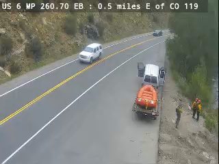 Emergency responders and a trailer with a raft are on the side of the road.