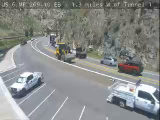 Construction vehicles and workers on the roadway, possibly responding to an incident.