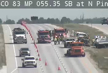 Emergency responders and vehicles are present on the roadway, indicating an incident.