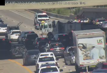 Traffic incident with emergency responders and a damaged truck on the highway.