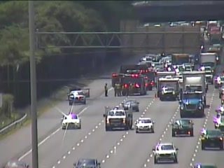 Emergency responders and vehicles on the highway, indicating an incident.