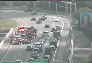 Fire truck and emergency vehicle with red and blue lights on the left shoulder