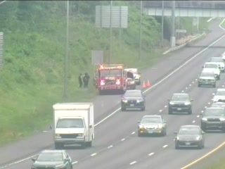 Fire truck with flashing red and blue lights on the right shoulder