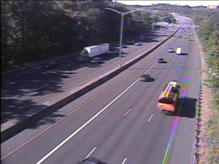 Emergency vehicle with flashing lights on the right shoulder of the highway.