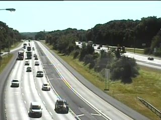Emergency responders and vehicles are visible on the side of the highway.
