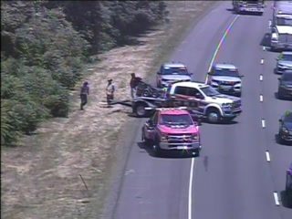 Tow truck and people on the side of the road, possibly responding to an incident.