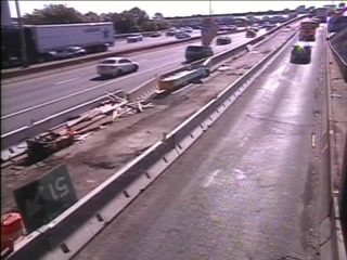 Debris and construction materials are scattered on the side of the highway.