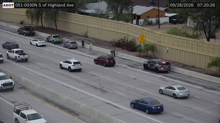 Police SUV with red and blue lights on the right shoulder