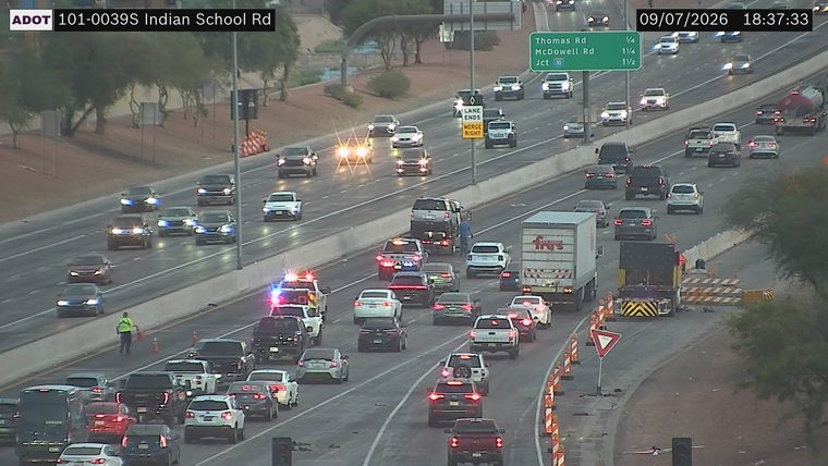 Police car with red and blue lights on the left shoulder