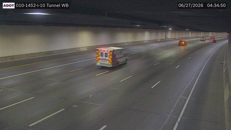 Ambulance with flashing lights in the left lane