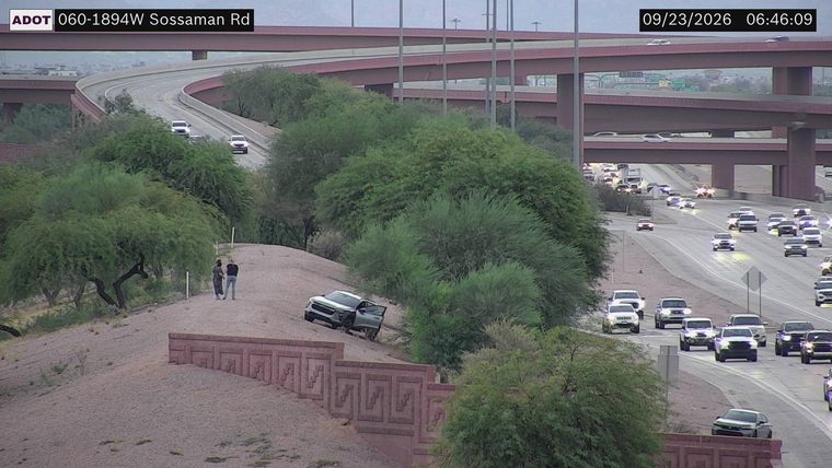Silver SUV off the roadway with the driver's door open
