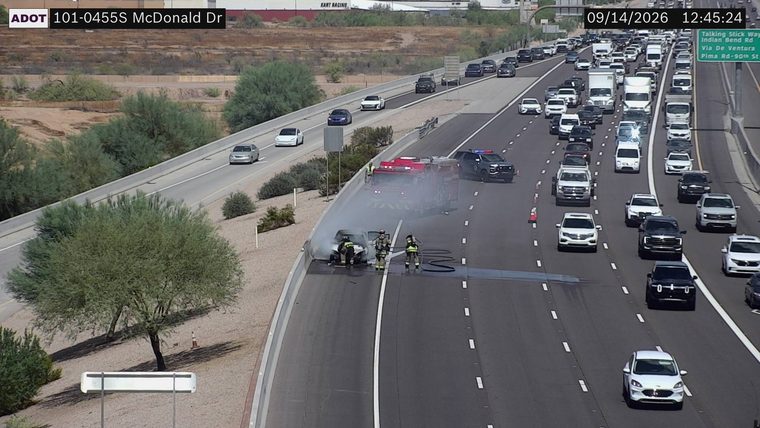 Car fire with firefighters and a police vehicle on the right shoulder
