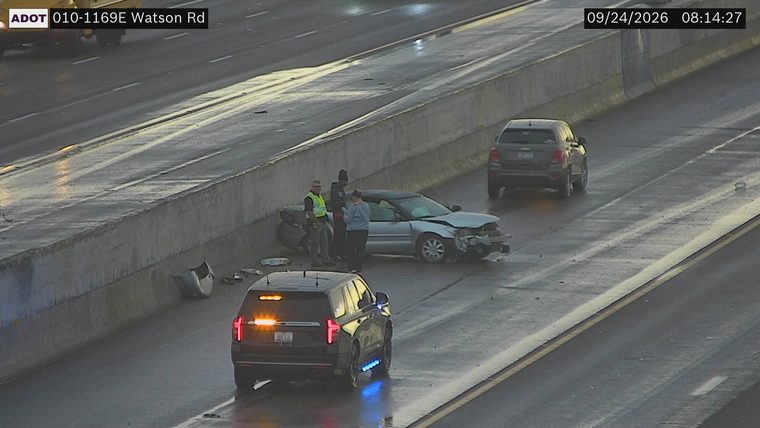 Damaged sedan and a police SUV with lights on in the right lane