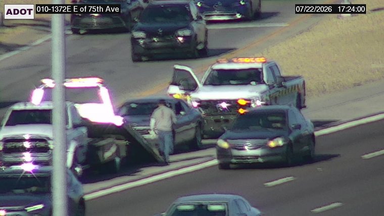 Tow truck assisting a car on the right shoulder