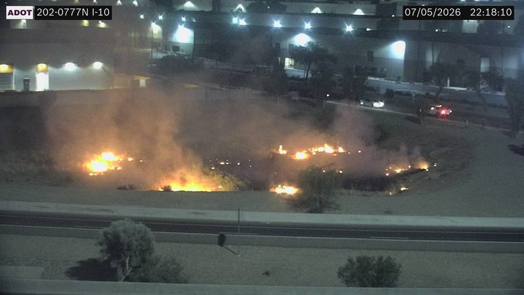 Brush fire with smoke and flames in the median area