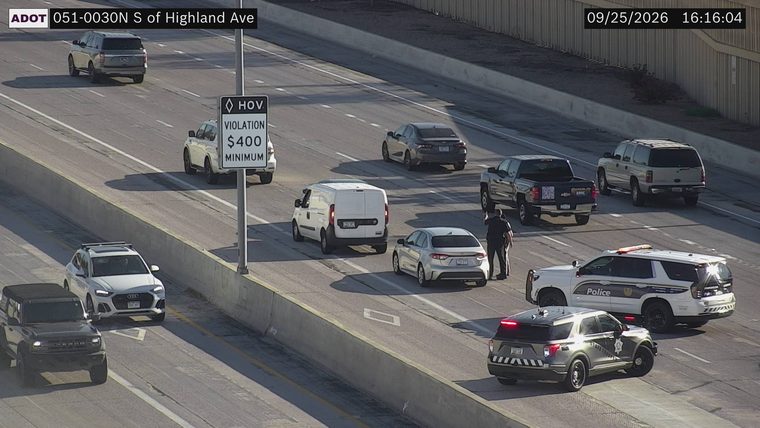 Two police vehicles with lights on in the right lane