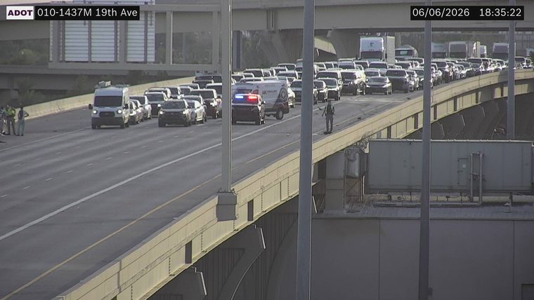Police car with lights on in the left lane