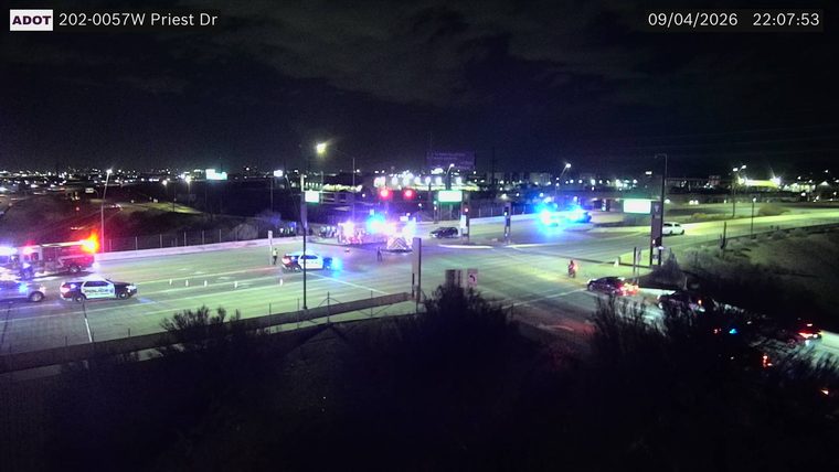 Multiple emergency vehicles including police and fire trucks with flashing lights at an intersection