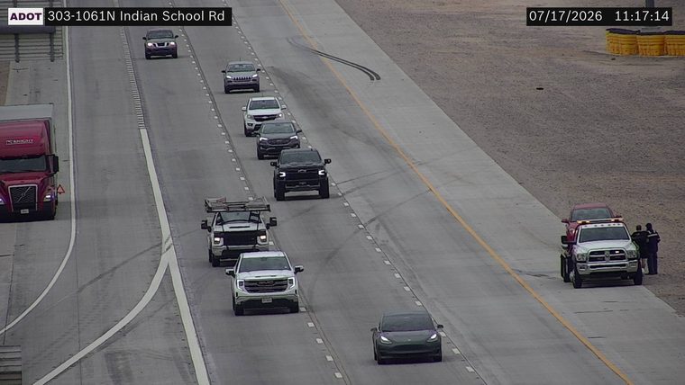 Tow truck assisting a red car on the right shoulder