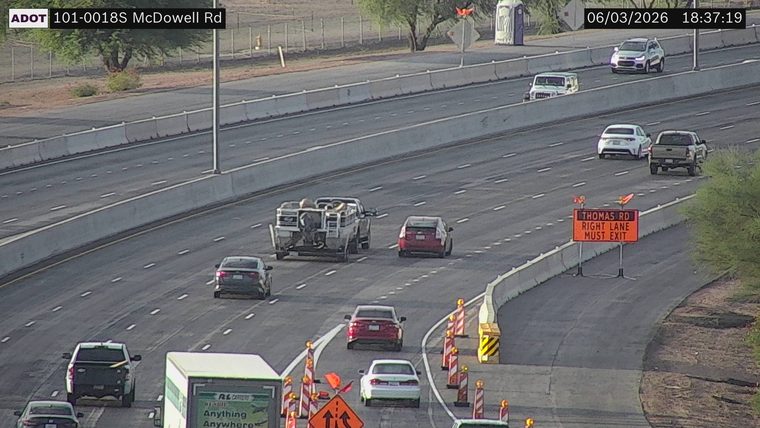 Construction cones and a sign indicating 'THOMAS RD RIGHT LANE MUST EXIT' in the right lane