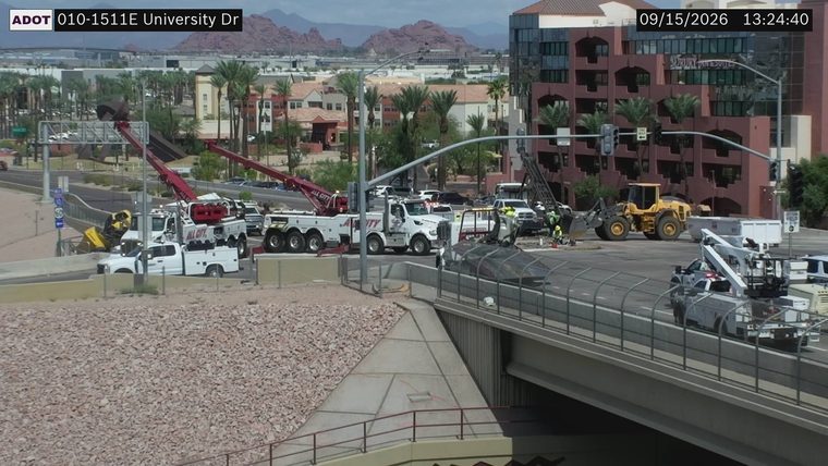 Multiple tow trucks and workers at an intersection