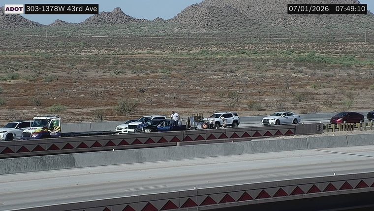 Tow truck assisting a damaged vehicle in the left lane