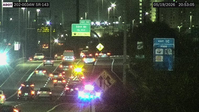 Emergency vehicle with flashing blue and red lights on the right shoulder