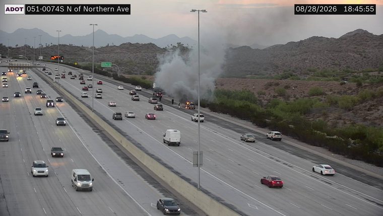 Vehicle on fire in the right lane with smoke billowing
