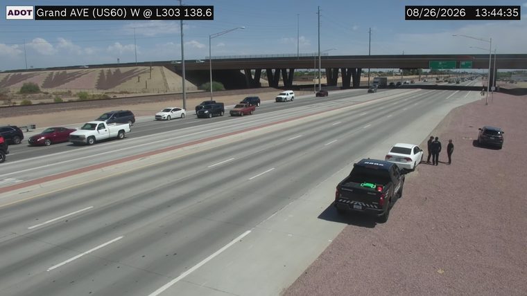 Police vehicle with officers and civilians on the right shoulder