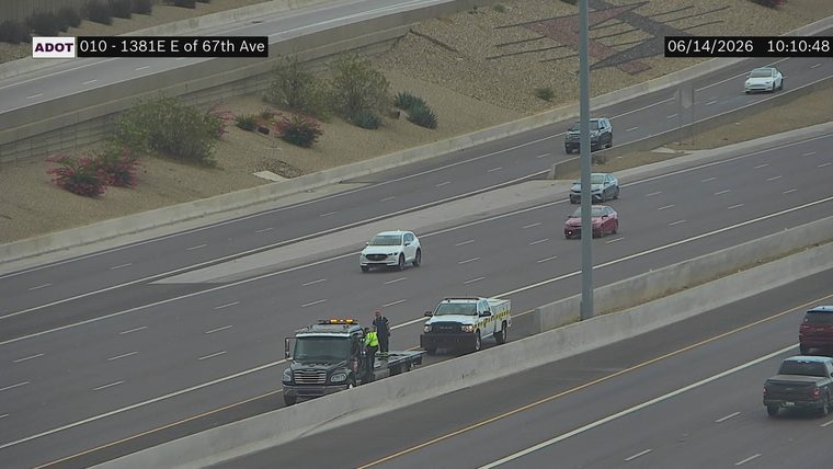 Tow truck and a worker on the right shoulder