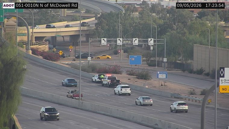 Tow truck with hazard lights on and a person in hi-viz vest in the right lane