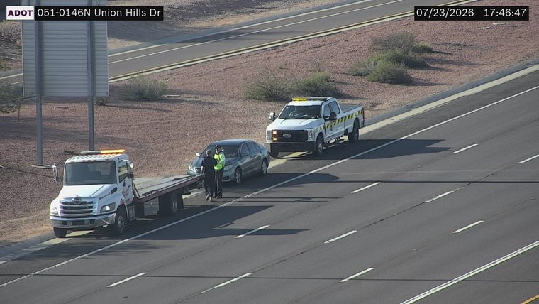 Tow truck and service truck assisting a car on the right shoulder