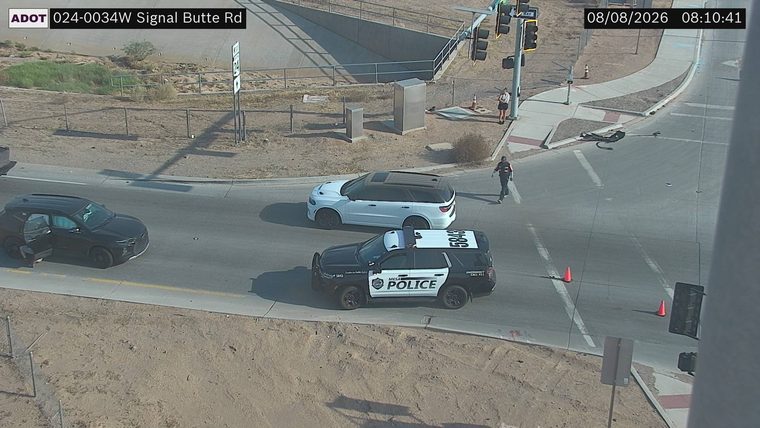 Police car and a person standing near a white SUV in the intersection