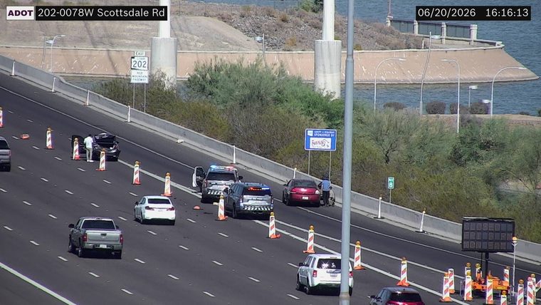 Police car with lights on the shoulder next to a damaged vehicle