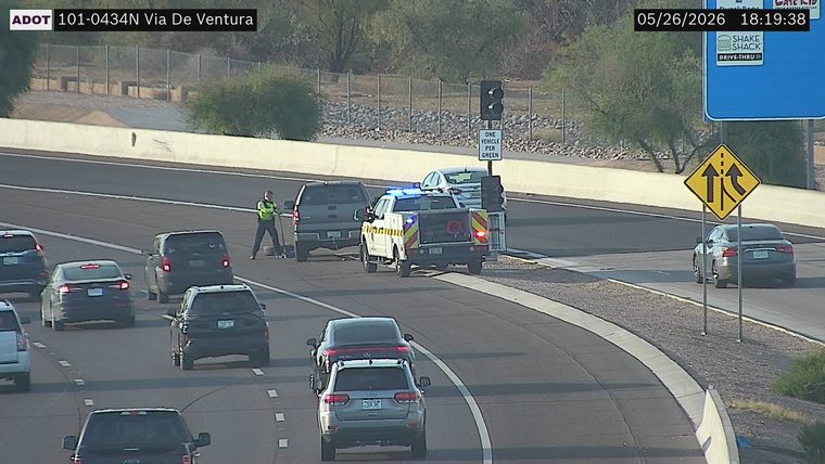 ADOT service patrol truck with flashing lights and a responder standing next to a grey pickup truck on the ramp shoulder