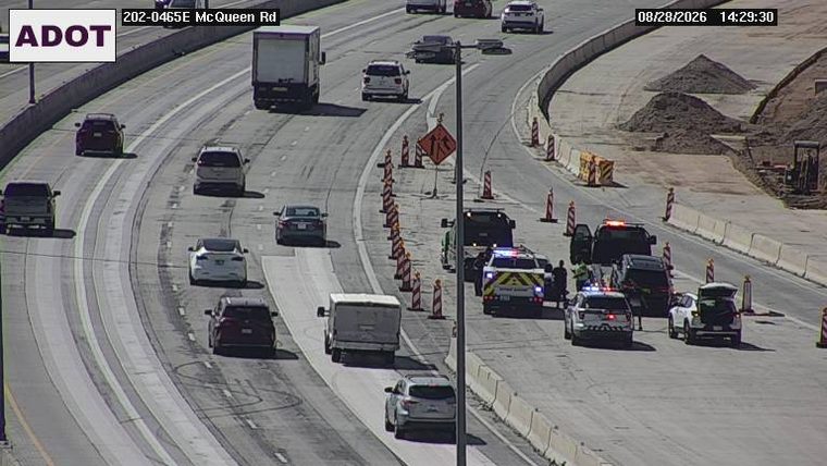 Multiple police vehicles and a tow truck with a vehicle on the right shoulder
