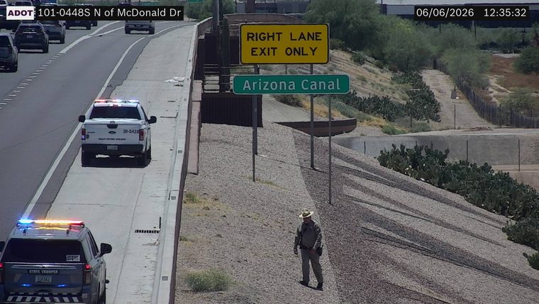 State trooper and Salt River Police vehicle with lights on, and a person in uniform on the shoulder
